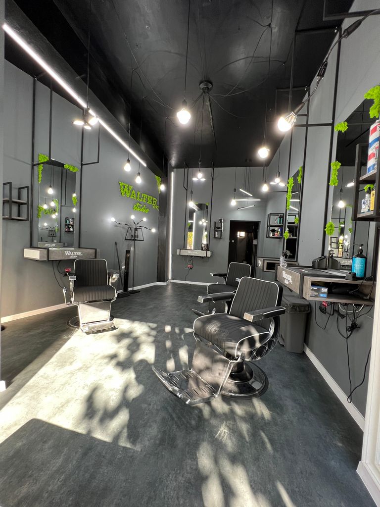 Interiorul Walter Studio: scaune de frizerie, pereți gri și benzi de lumină pe tavan